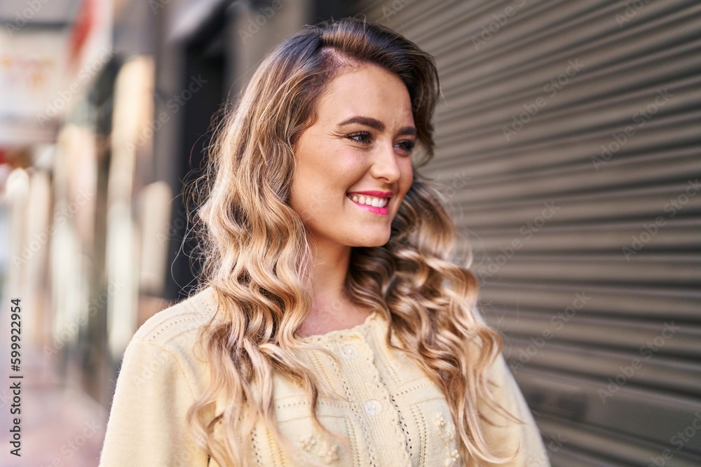 Fototapeta premium Young woman smiling confident looking to the side at street