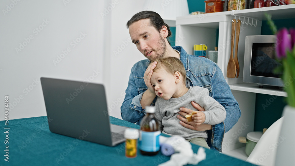 Father and son using laptop having online medical consultation at dinning room Father and son using laptop having online medical consultation at dinning room