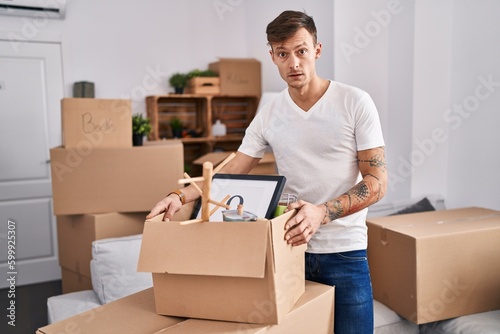 Caucasian man holding screwdriver at new home scared and amazed with open mouth for surprise, disbelief face
