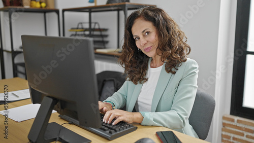 Middle age hispanic woman business worker using computer working at office