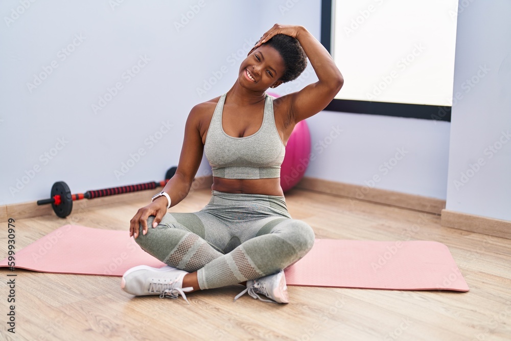 African american woman smiling confident stretching neck at sport center African american woman smiling confident stretching neck at sport center
