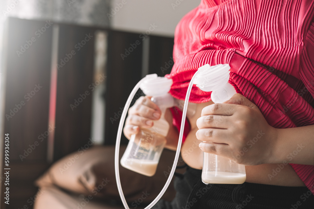 Foto de Mom using breast pump machine to pumping milk for her son in