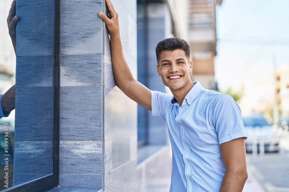 Fototapeta premium Young hispanic man smiling confident standing at street
