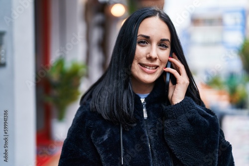Young caucasian woman smiling confident talking on smartphone at street