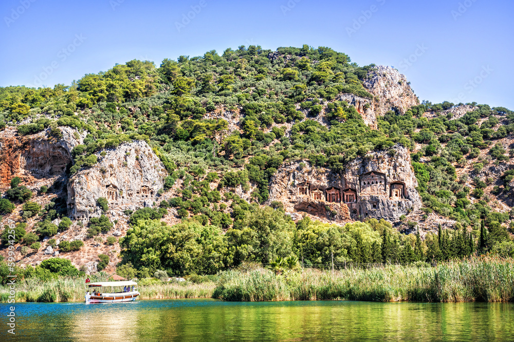 Boat near the shore, Lycian tombs in the rocks, Dalyan river, Mediterranean Sea, Marmaris, Turkey