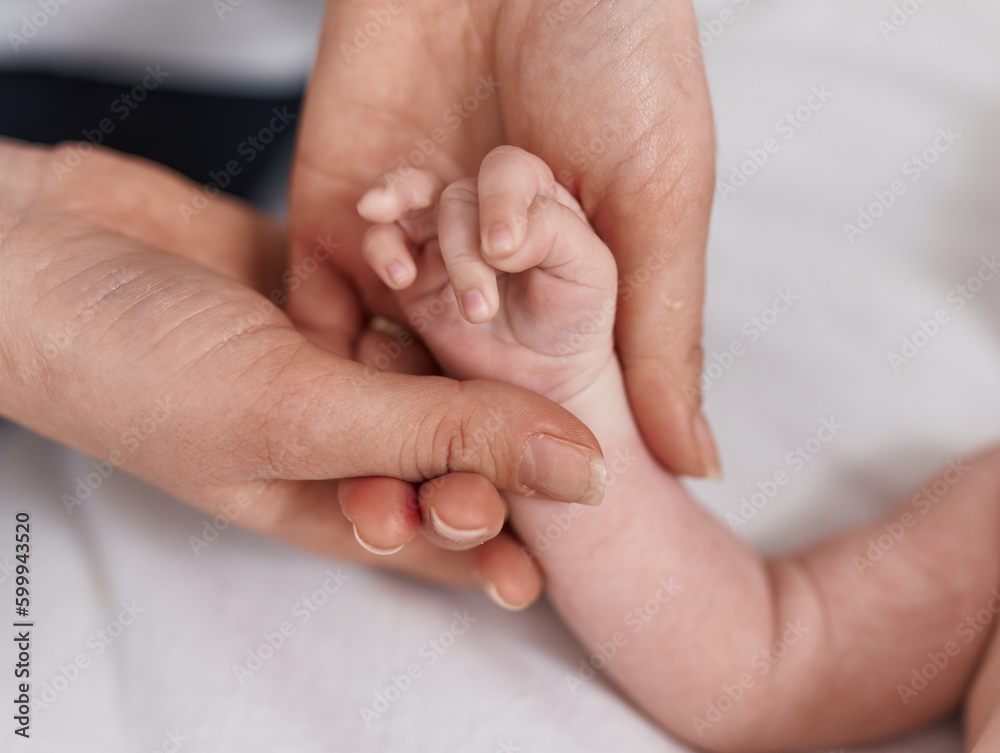 Adorable caucasian baby lying on bed having hand massage at bedroom Adorable caucasian baby lying on bed having hand massage at bedroom