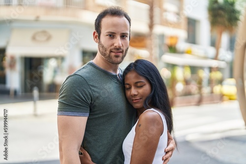 Man and woman interracial couple hugging each other at street © Krakenimages.com