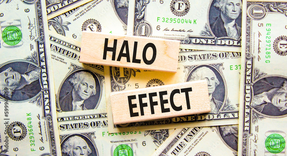 Halo effect and psychological symbol. Concept words Halo effect on beautiful wooden block. Beautiful background from dollar bills. Business psychological and Halo effect concept. Copy space.