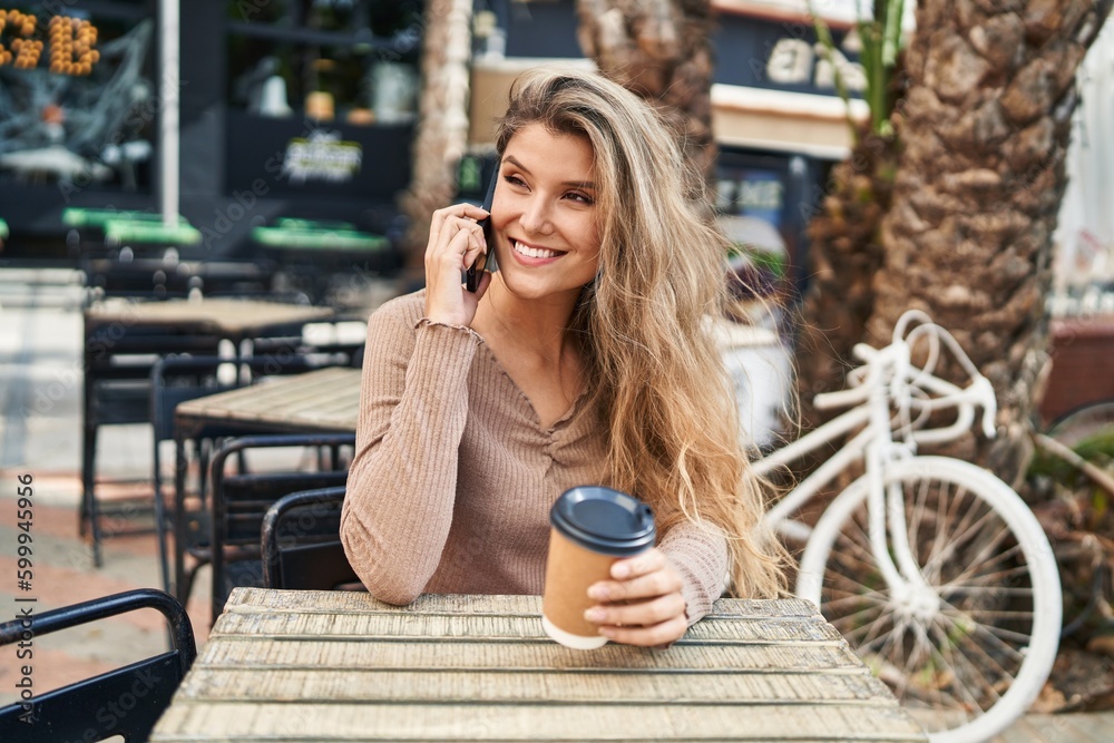 Young blonde woman talking on the smartphone drinking coffee at coffee shop terrace Young blonde woman talking on the smartphone drinking coffee at coffee shop terrace