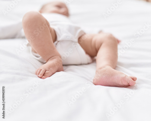 Adorable caucasian baby lying on bed at bedroom