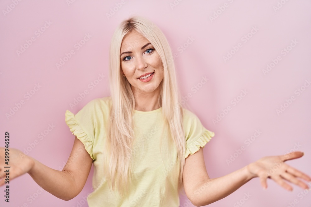 Caucasian woman standing over pink background smiling cheerful offering hands giving assistance and acceptance. Caucasian woman standing over pink background smiling cheerful offering hands giving assistance and acceptance.