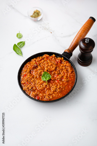 Bolognese sauce in skillet pan on light surface