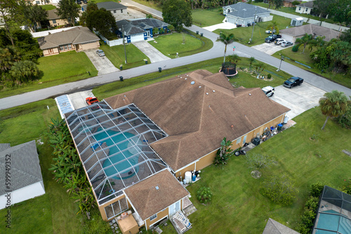 Fotografija Aerial view of typical contemporary american private house with outside lanai enclosure covering big swimming pool