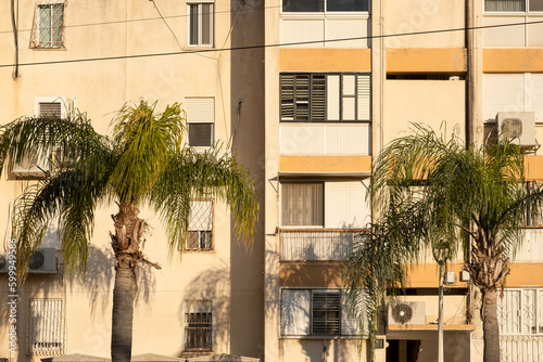 Typical old aged Architecture in Israel street. 60s buildings with fascade wall .windows after Palm trees photo