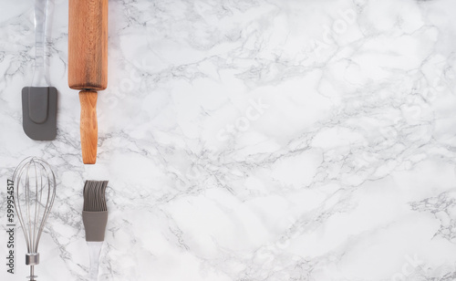 Cooking tools on a marble counter with space for lettering