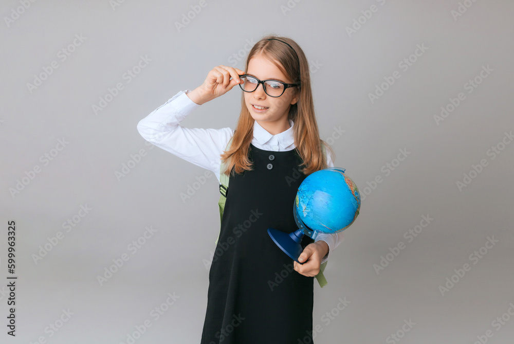 Caucasian young teenager schoolgirl student holding a globe on a gray background, isolated. Happy earth day Caucasian young teenager schoolgirl student holding a globe on a gray background, isolated. Happy earth day