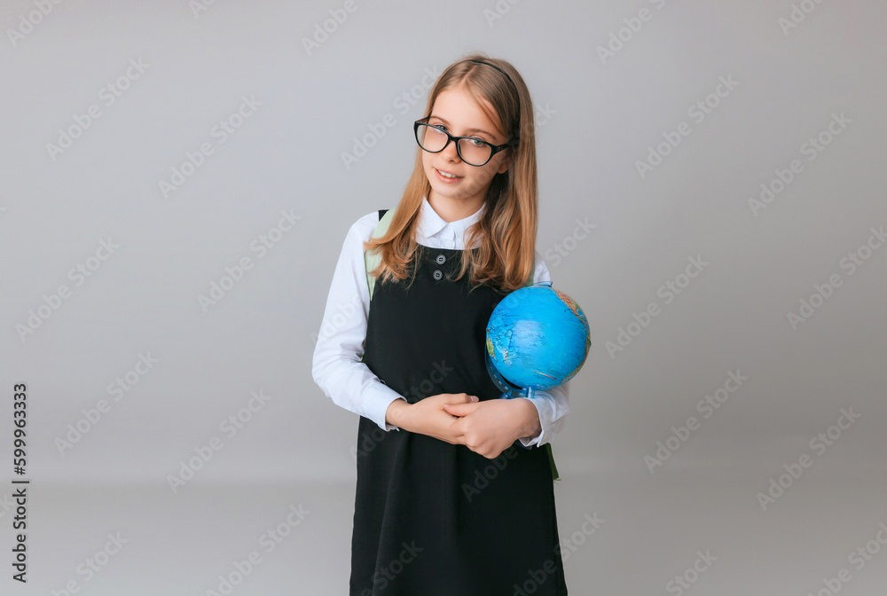 Caucasian young teenager schoolgirl student holding a globe on a gray background, isolated. Happy earth day Caucasian young teenager schoolgirl student holding a globe on a gray background, isolated. Happy earth day