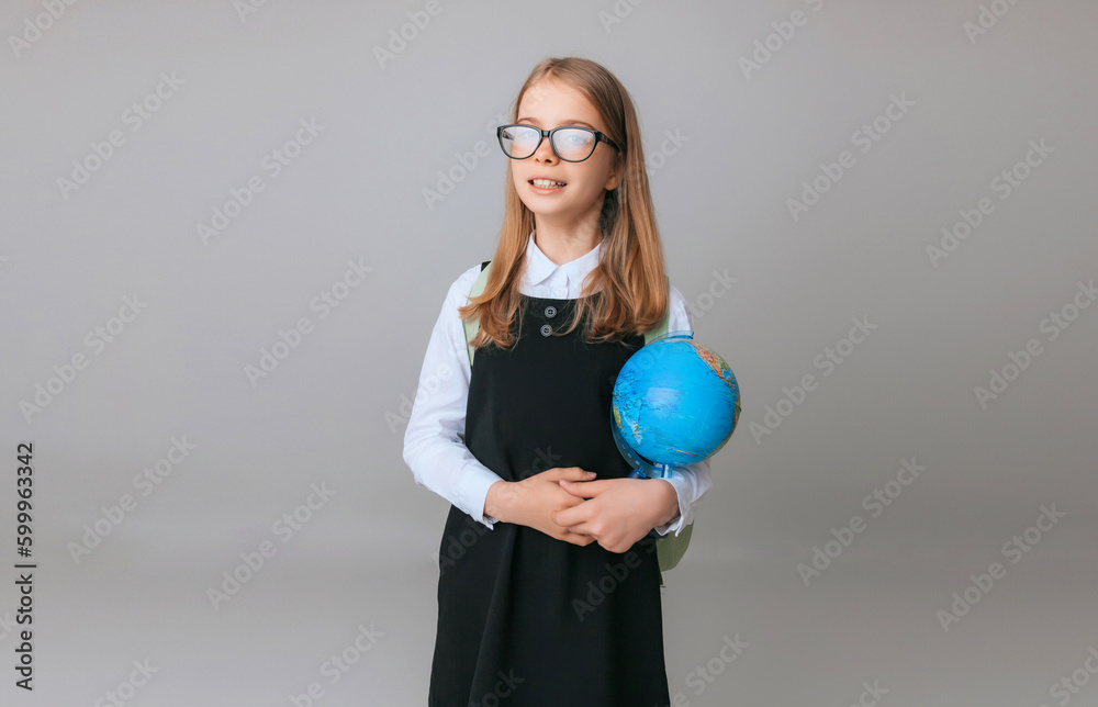 Caucasian young teenager schoolgirl student holding a globe on a gray background, isolated. Happy earth day Caucasian young teenager schoolgirl student holding a globe on a gray background, isolated. Happy earth day