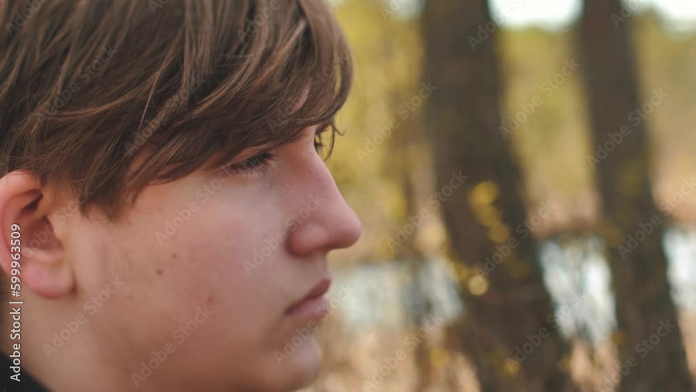 A guy spends time alone in nature. Solitude and thoughts about life. Depressed young man alone with himself. Soft selective focus.
