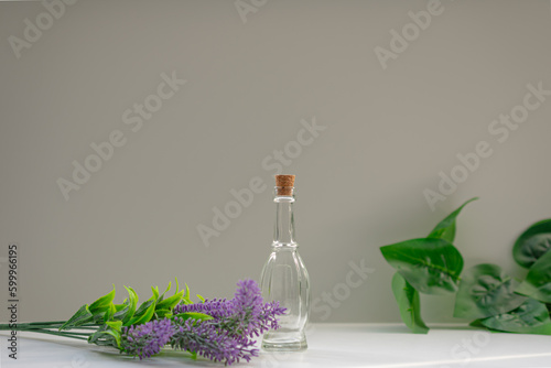 Empty glass bottle with a cork cap, surrounded with plants. Aromatherapy,lavender oil concepts