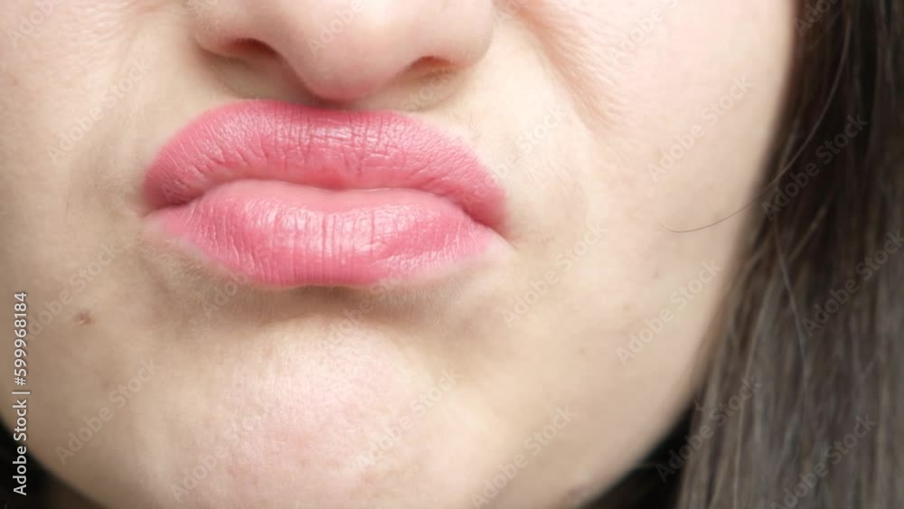 The woman's disgruntled lips stretch forward and to the side, an unpleasant smell, a grimace The woman's disgruntled lips stretch forward and to the side, an unpleasant smell, a grimace