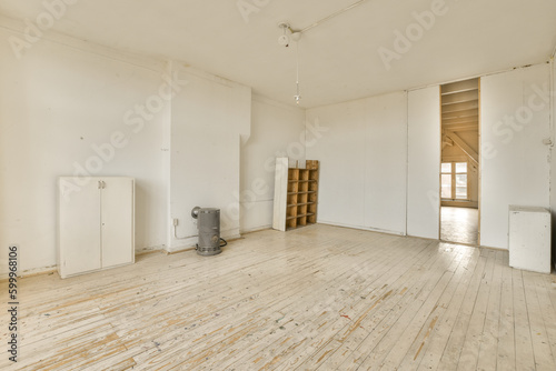 an empty room with white walls and wood flooring on one side  there is a heater in the corner