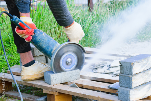 the process of sawing paving slabs by a worker