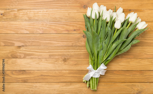 White tulip bouquet on wooden background  top view