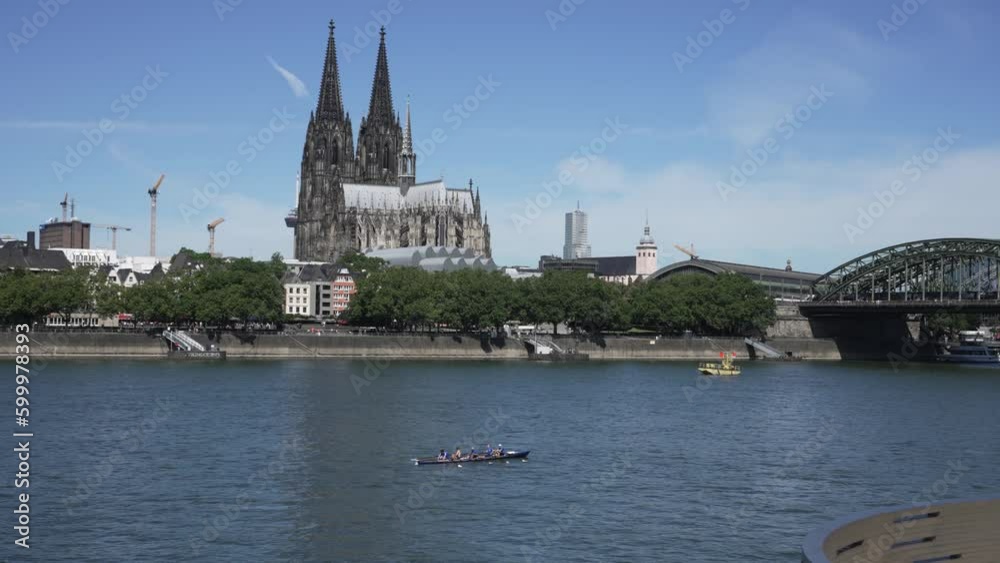 People rowing at Rhine river on sunny day in Cologne with view of Dom cathedral at background People rowing at Rhine river on sunny day in Cologne with view of Dom cathedral at background