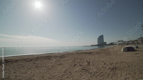 Playa de Barcelona sin gente, el ambiente es tranquilo y el cielo azul filtra los rayos del sol