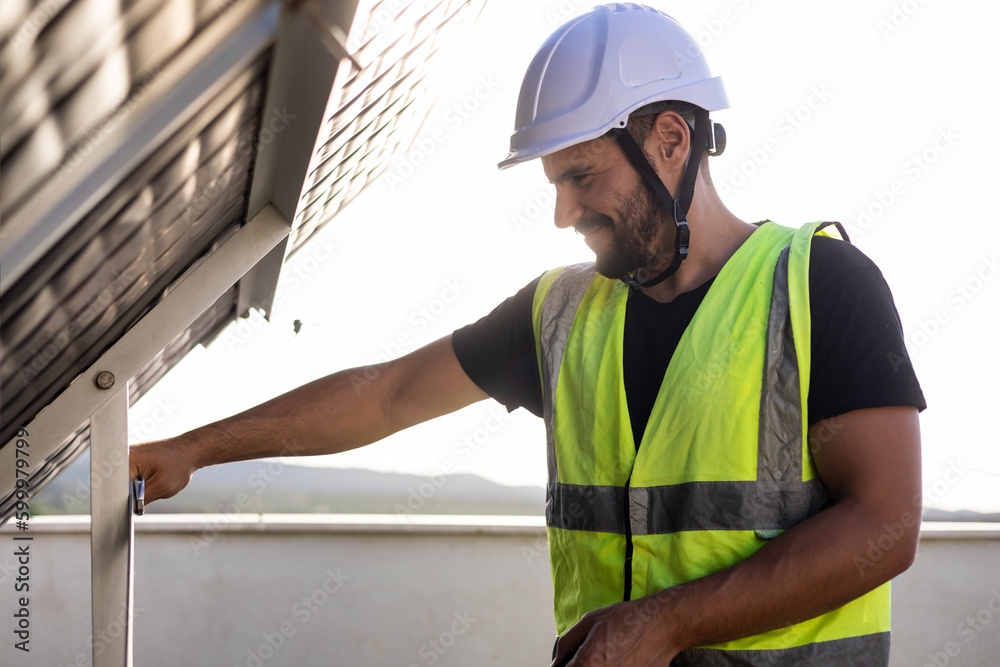 A specialist engineer in protective clothing is adjusting a nut with a faucet of a solar hot water panel to place it. Concept of solar panels of hot water, renewable energy.Green energy. A specialist engineer in protective clothing is adjusting a nut with a faucet of a solar hot water panel to place it. Concept of solar panels of hot water, renewable energy.Green energy.