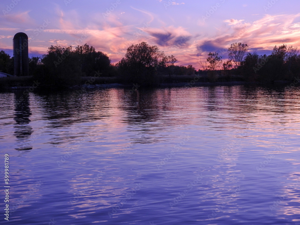 Naklejka premium purple sky on the water with silo in the background