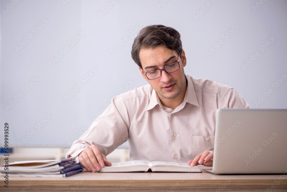 Young male teacher student sitting in the classroom Young male teacher student sitting in the classroom