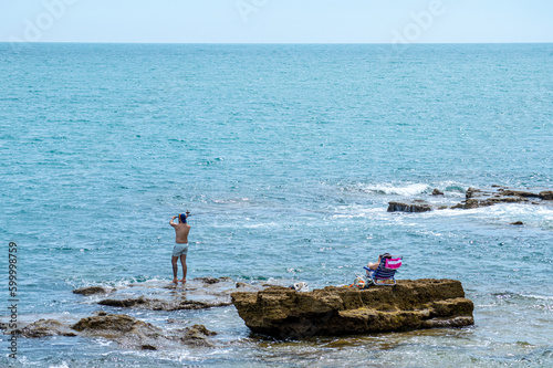 Relaxing on stones near Saint Sebastian castle in Cadiz, Spain on April 30, 2023