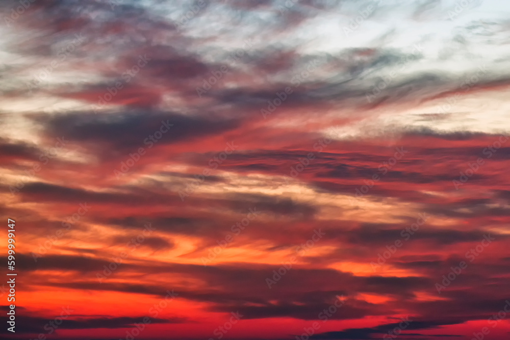 Background of the red, black and white cumulus clouds under the beautiful dramatic sunset sky. Clouds exert numerous influences on Earth's troposphere and climate.	