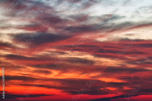 Background of the red, black and white cumulus clouds under the beautiful dramatic sunset sky. Clouds exert numerous influences on Earth's troposphere and climate. 