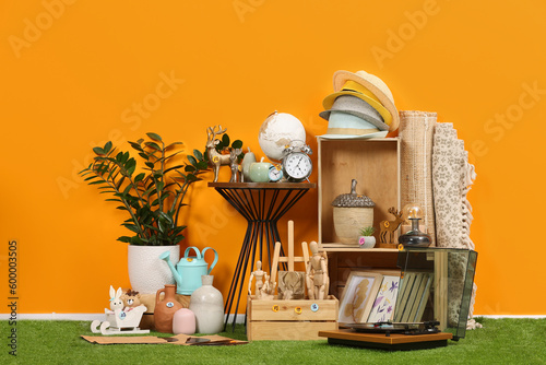 Many different items near orange wall in room. Garage sale photo