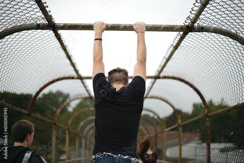 person hanging from an overpass fence © Traysaun