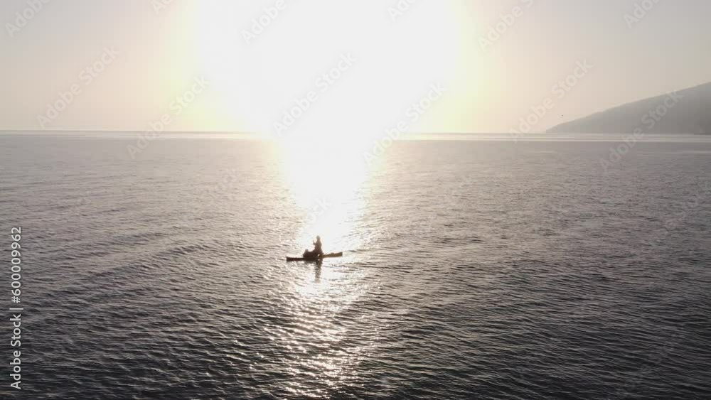 girl silhouette swims on a SUP board with a dog on ocean and is filmed by a drone for a video blog. Sports, active recreation, surfing. girl silhouette swims on a SUP board with a dog on ocean and is filmed by a drone for a video blog. Sports, active recreation, surfing.