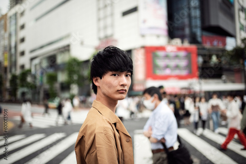 渋谷のスクランブル交差点を歩く若い男性