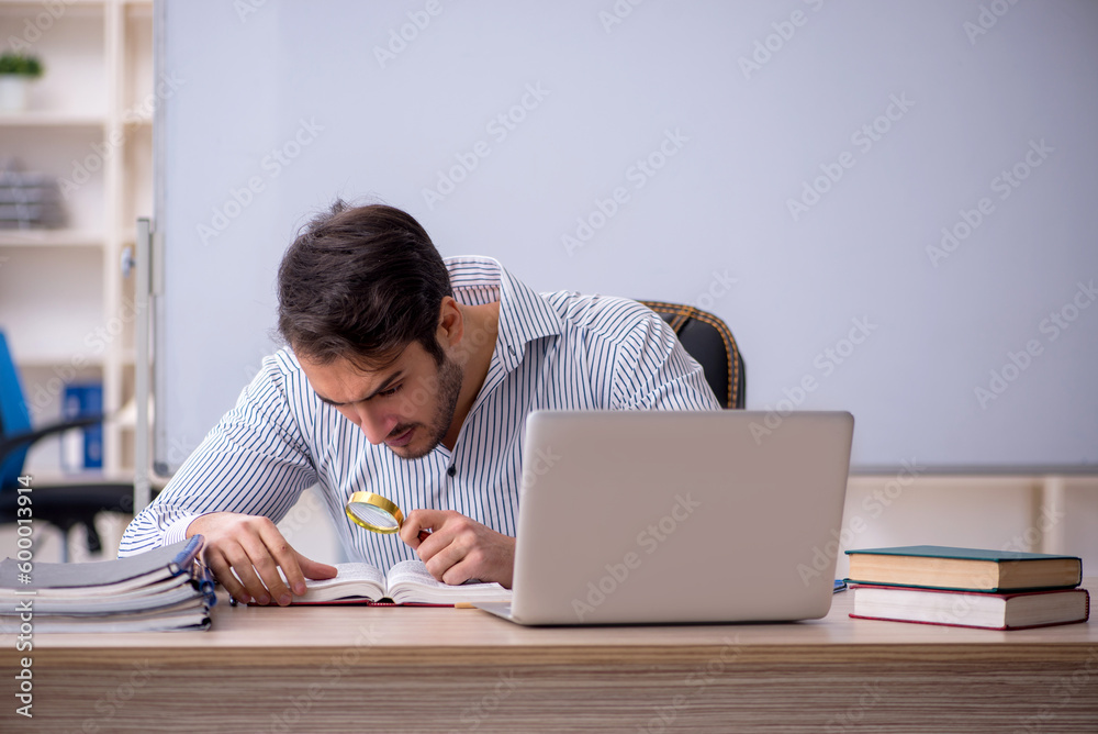 Young male teacher sitting in the classroom Young male teacher sitting in the classroom