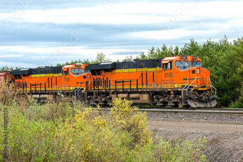 Dual engine freight train pulling cargo on a warm spring day close to Whitefish, Montana