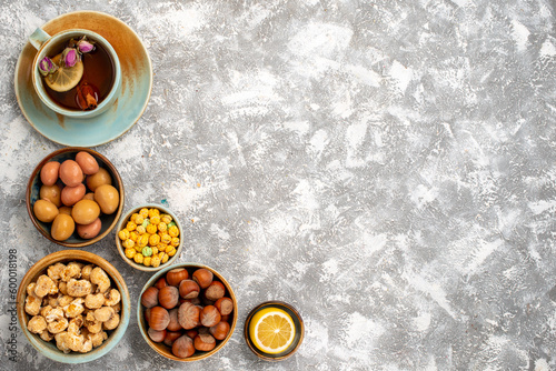 top view cup of tea with nuts and candies on white background nut tea candy snack