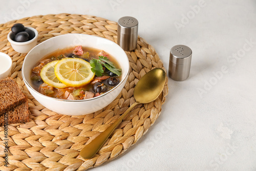 Bowl of tasty Hodgepodge soup on light background photo
