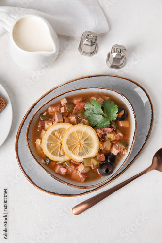 Bowl of tasty Hodgepodge soup on light background photo