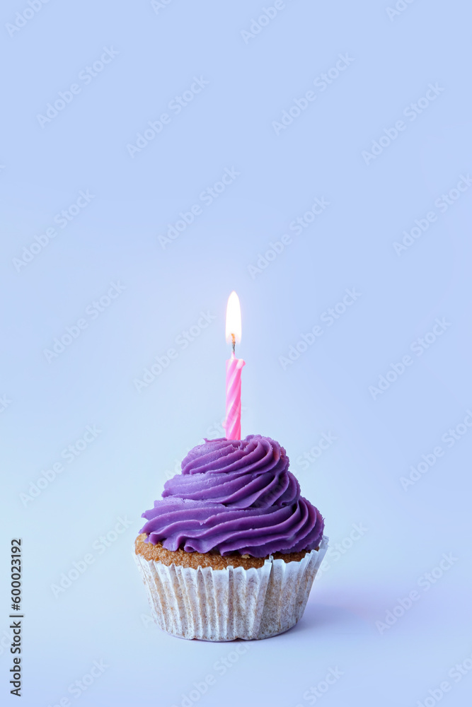 Tasty cupcake with birthday candle on blue background Tasty cupcake with birthday candle on blue background