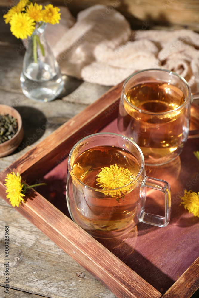Board with glass cups of healthy dandelion tea on wooden table Board with glass cups of healthy dandelion tea on wooden table