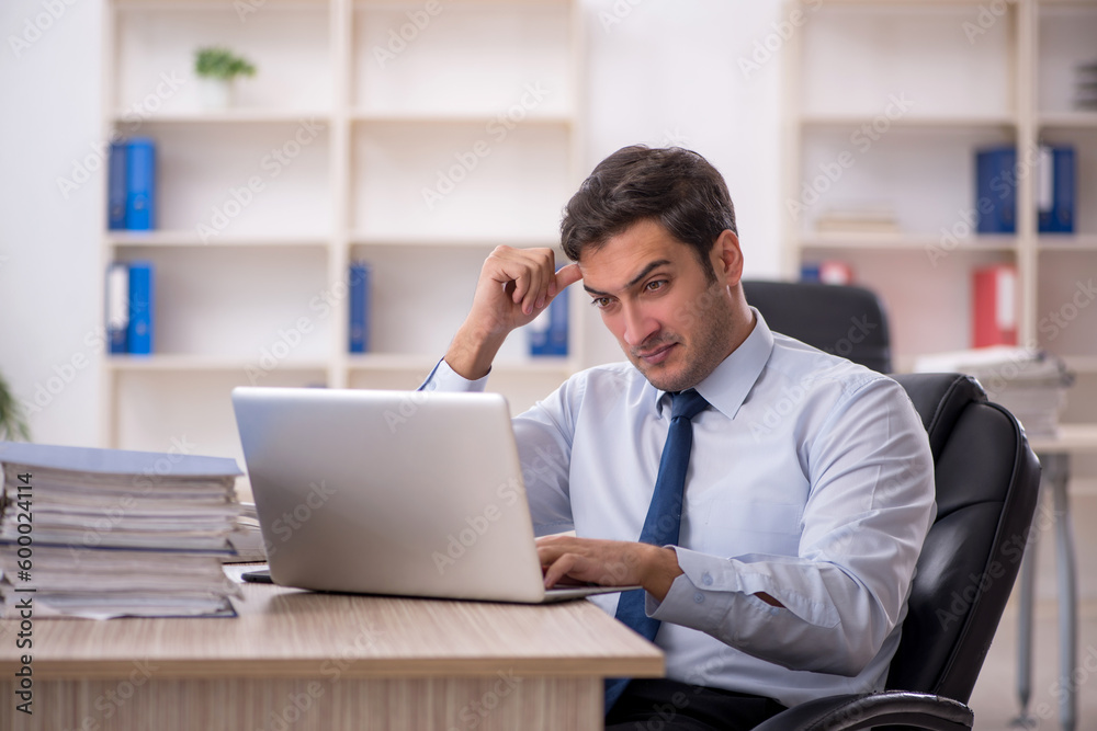 Young male employee working in the office Young male employee working in the office