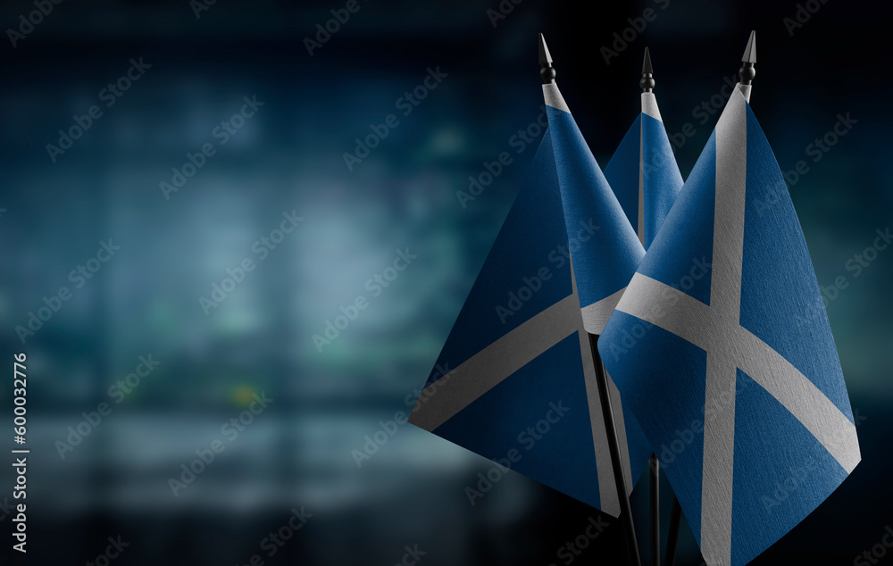 Small flags of the Scotland on an abstract blurry background