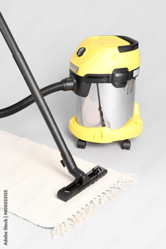 Vacuum cleaner with rug on grey background Vacuum cleaner with rug on grey background